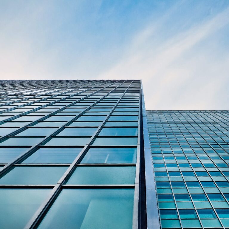 Tall building perspective. Glass and blue skies with light cloud cover