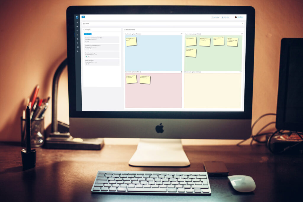 Desktop with iMac and DigiLEAN improvements prioritization matrix