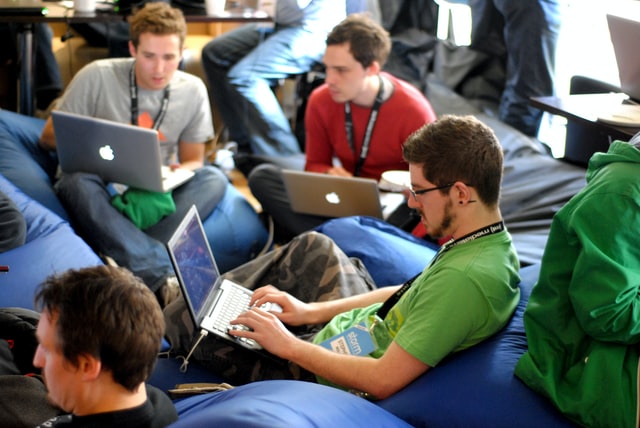 Innovative and modern workplace without traditional desks. Employees sitting with laptops in bean bags.