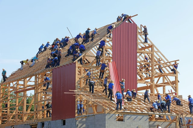 Numerous construction workers on a building